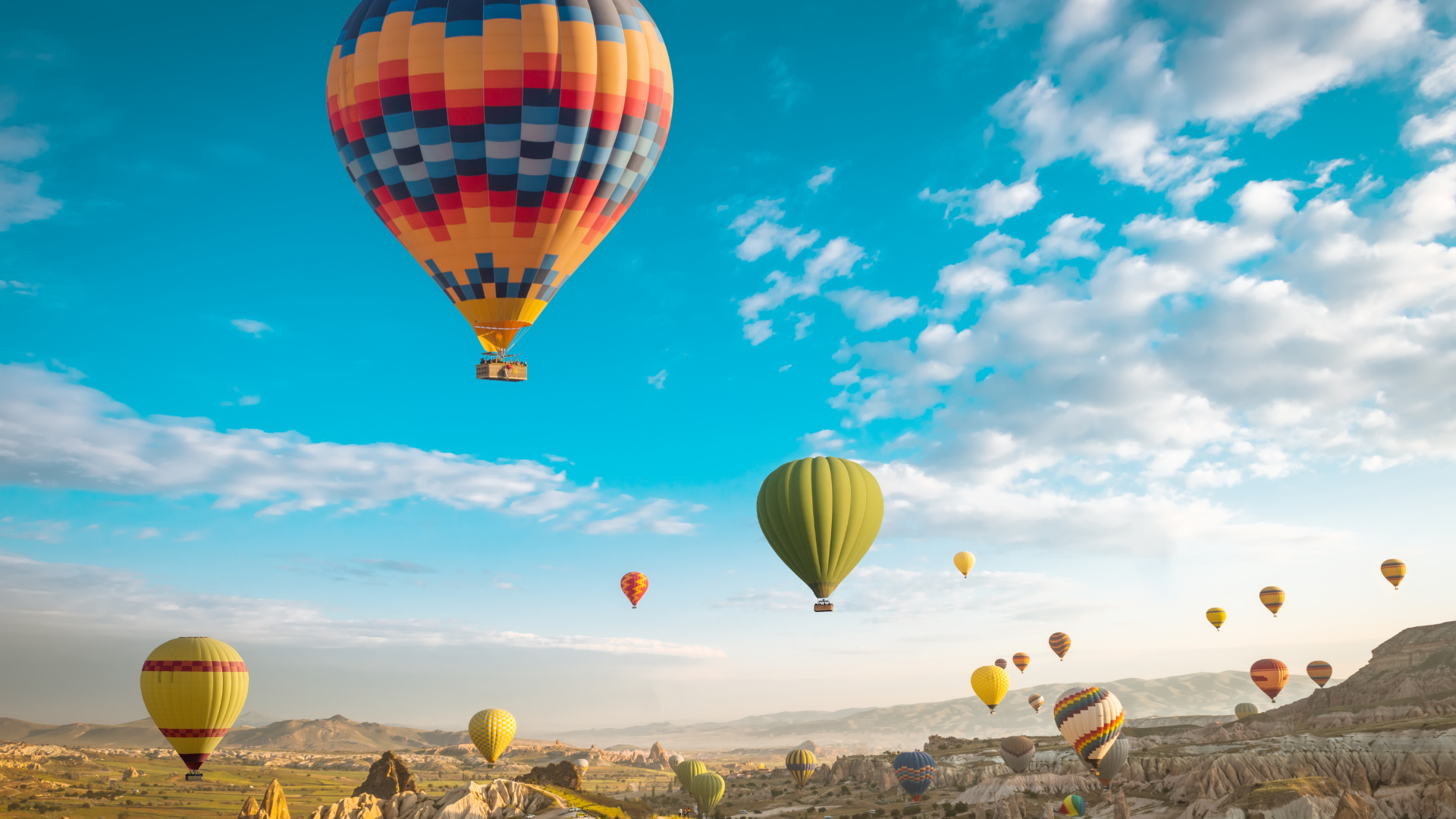 baner zdjecie lecace balony wieksza czesc zdjecia to niebo blekitne z delikatnymi chmurami leca nad kanionem kilaknascie kolorowych balonow w roznych odleglosciach